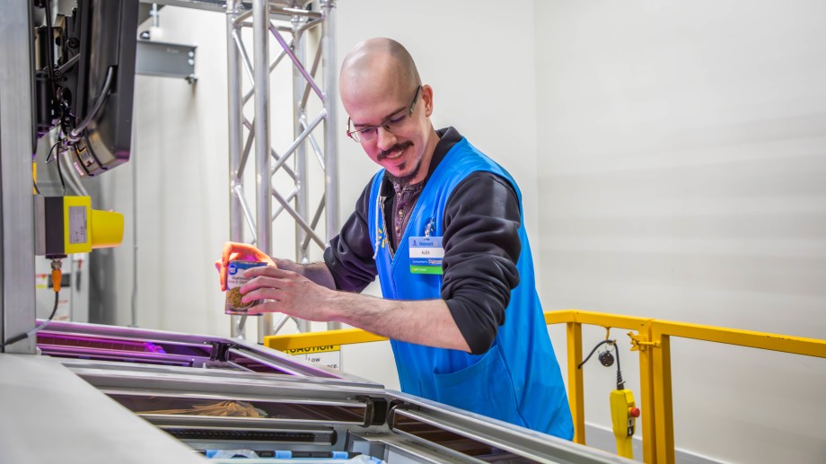 Male associate scanning items are a market fulfillment center.