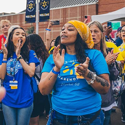 Associates clap, cheer and take pictures outside the Bud Walton Arena in Fayetteville, Arkansas, at 2024 Associates Week.